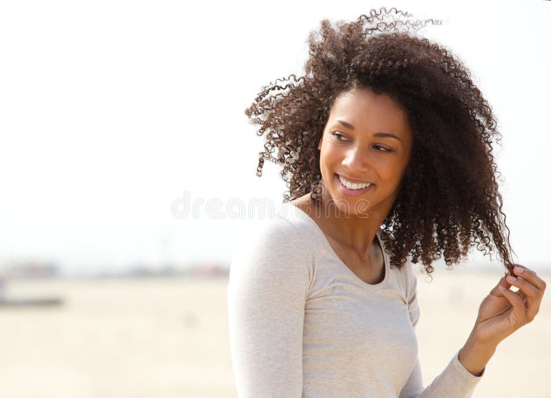 Giovane donna che sorride con i capelli ricci