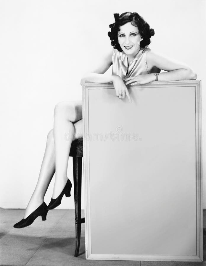 Giovane donna che tiene un segno (tutte le persone rappresentate non sono vivente più lungo e nessuna proprietà esiste Garanzie d immagine stock Giovane donna che tiene un segno (tutte le persone rappresentate non sono vivente più lungo e nessuna proprietà esiste Garanzie d immagine stock