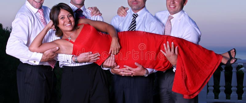 Giovane donna che è alzata dai quattro uomo ad un partito immagine stock Giovane donna che è alzata dai quattro uomo ad un partito immagine stock