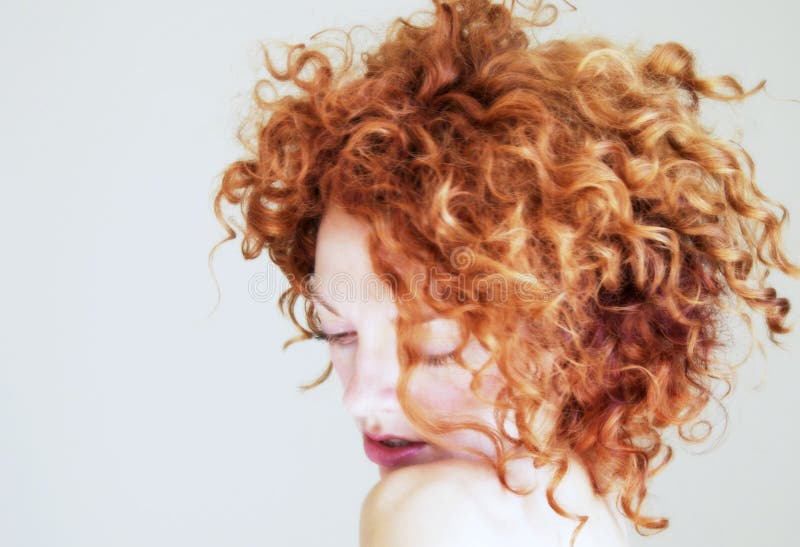Giovane donna con capelli rossi ricci che sono timidi Giovane donna con capelli rossi ricci che sono timidi