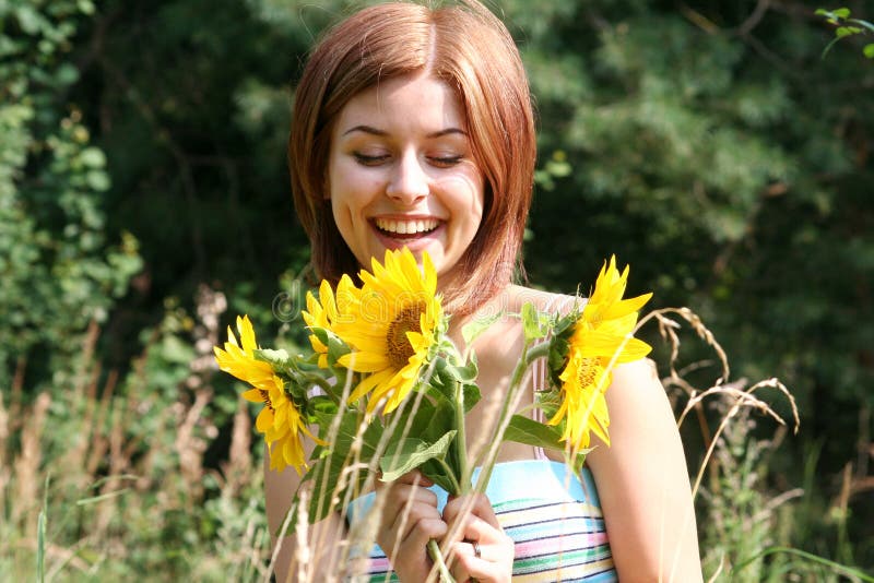Giovane donna con i girasoli immagini stock libere da diritti Giovane donna con i girasoli immagini stock libere da diritti