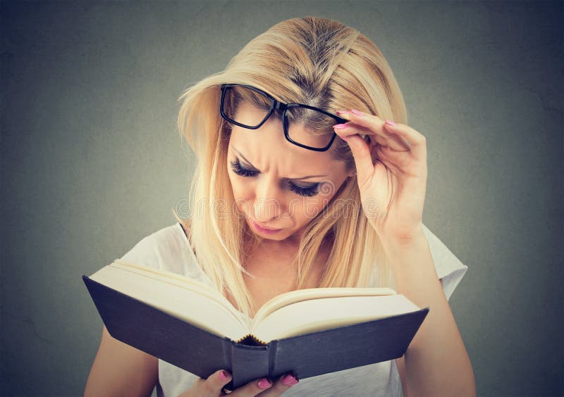 Giovane donna con i vetri che soffrono dall'affaticamento della vista dopo la lettura del libro fotografia stock libera da diritti Giovane donna con i vetri che soffrono dall'affaticamento della vista dopo la lettura del libro fotografia stock libera da diritti