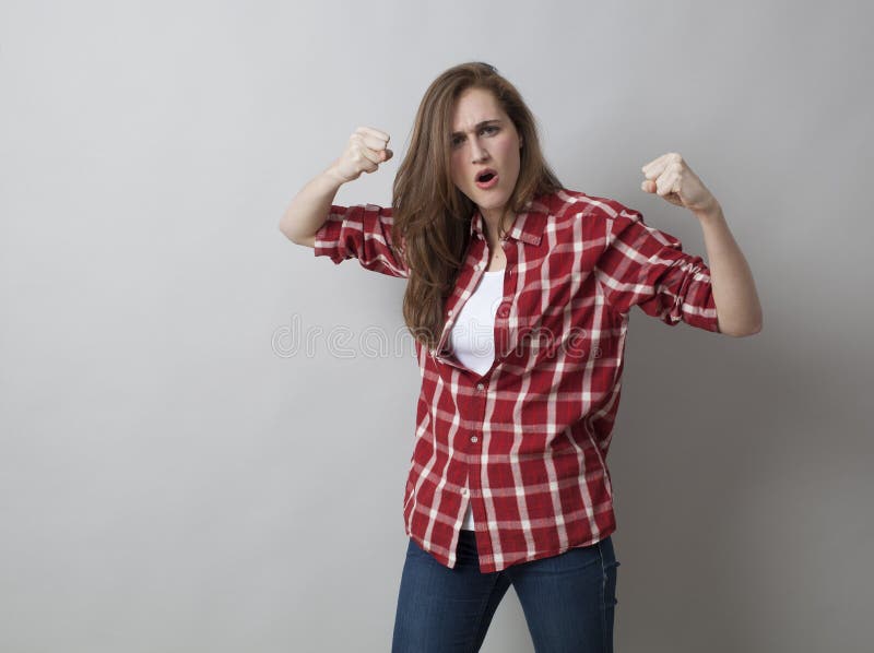 Giovane donna con la camicia controllata che esprime aggresion immagine stock Giovane donna con la camicia controllata che esprime aggresion immagine stock