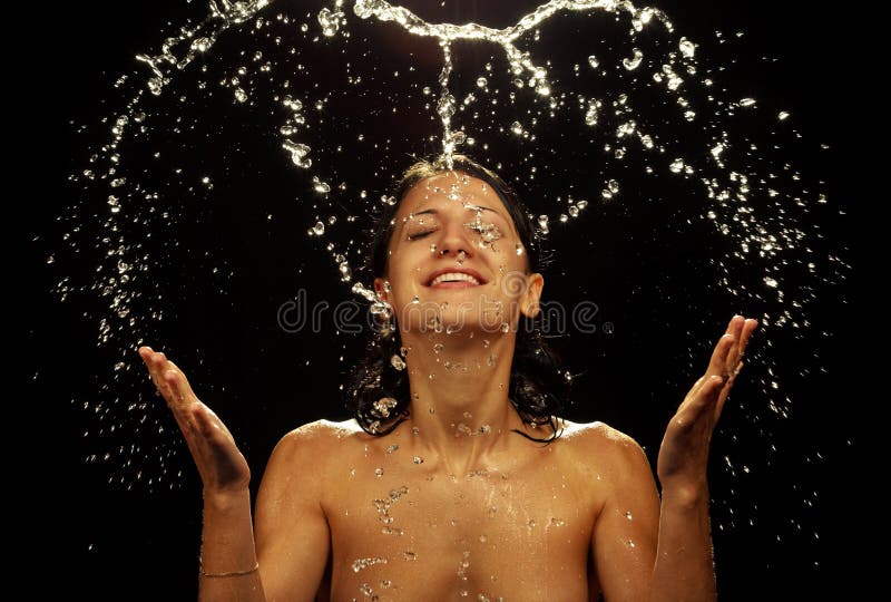 Portrait of beautiful young woman with drops of water around her face - horizontal. Close-up portrait on dark background. Portrait of beautiful young woman with drops of water around her face - horizontal. Close-up portrait on dark background