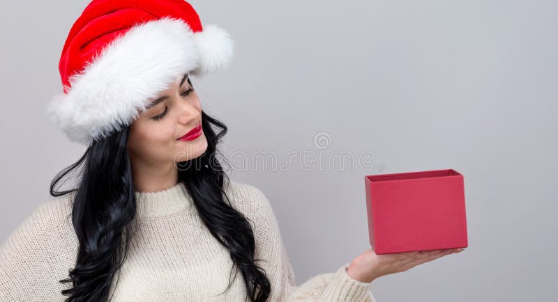 Giovane donna con santa che tiene in mano una scatola regalo fotografia stock