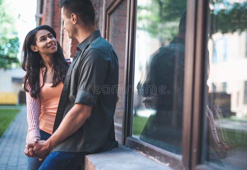 Giovane donna curiosa che ascolta il suo ragazzo e che lo esamina immagini stock Giovane donna curiosa che ascolta il suo ragazzo e che lo esamina immagini stock