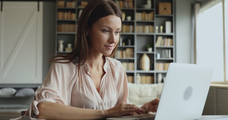 Giovane donna d'affari che scrive sul computer portatile siede a tavola stock footage