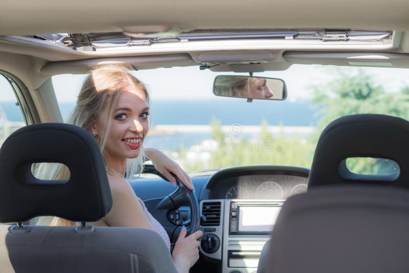Giovane donna del driver dietro il volante immagini stock libere da diritti Giovane donna del driver dietro il volante immagini stock libere da diritti