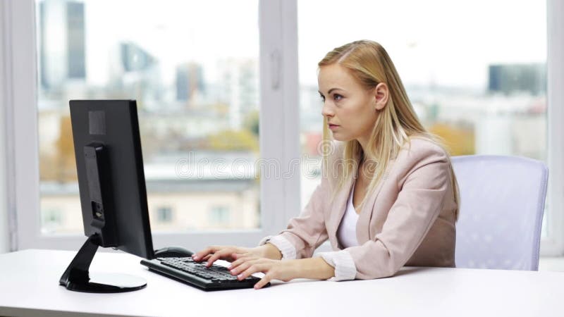 Giovane donna di affari con il computer che scrive all'ufficio