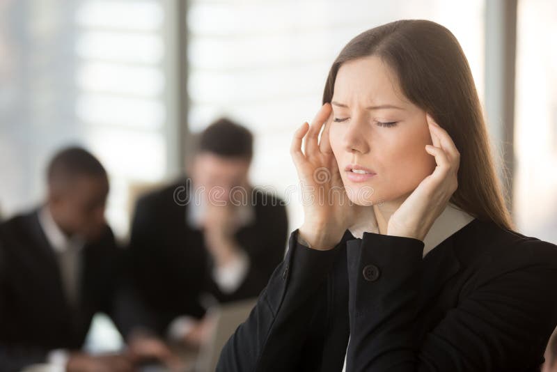 Giovane donna di affari frustrata che ritiene vertiginoso indisposto durante il meeti immagine stock Giovane donna di affari frustrata che ritiene vertiginoso indisposto durante il meeti immagine stock