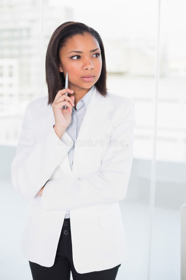 Giovane donna di affari mora attraente che posa distogliere lo sguardo immagine stock libera da diritti Giovane donna di affari mora attraente che posa distogliere lo sguardo immagine stock libera da diritti
