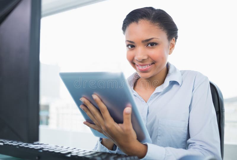 Giovane donna di affari mora divertente che per mezzo di un pc della compressa immagini stock Giovane donna di affari mora divertente che per mezzo di un pc della compressa immagini stock