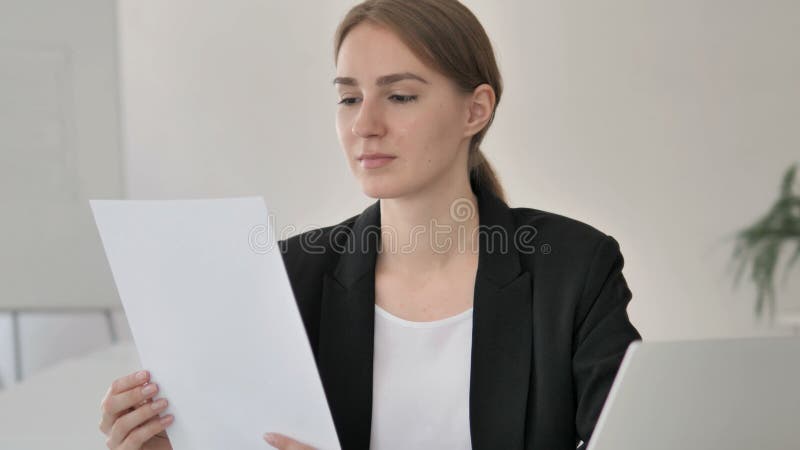 Giovane donna di affari Reading Documents sul lavoro