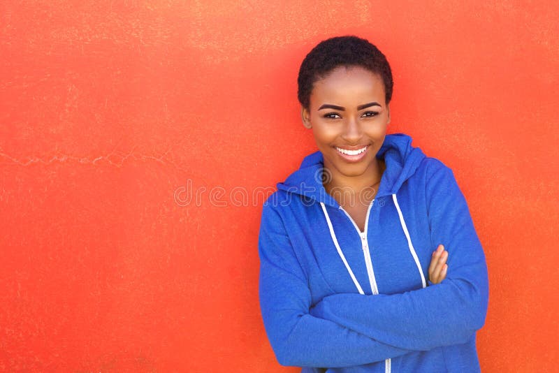 Giovane donna di colore attraente che sorride contro il fondo rosso immagini stock libere da diritti Giovane donna di colore attraente che sorride contro il fondo rosso immagini stock libere da diritti