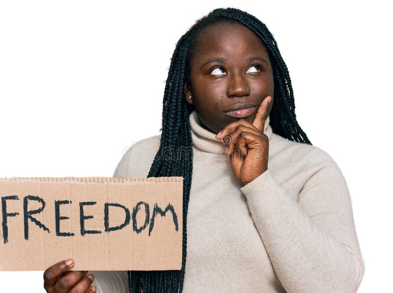 Young black woman with braids holding freedom banner serious face thinking about question with hand on chin, thoughtful about confusing idea. Young black woman with braids holding freedom banner serious face thinking about question with hand on chin, thoughtful about confusing idea
