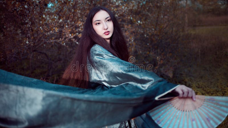 Giovane donna di dancing in kimono, costume asiatico fotografia stock libera da diritti Giovane donna di dancing in kimono, costume asiatico fotografia stock libera da diritti