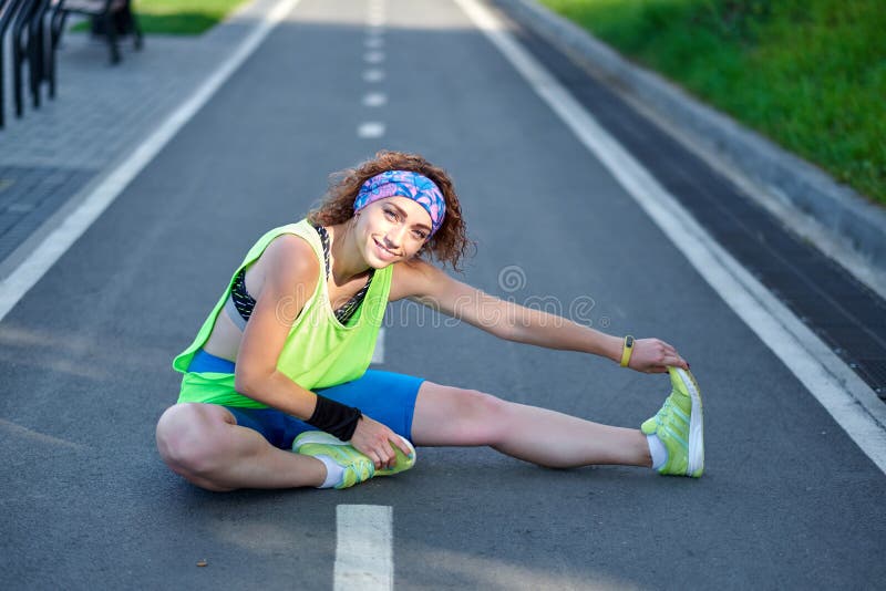Giovane donna di forma fisica che allunga le gambe dopo il funzionamento all'aperto dopo il funzionamento immagine stock libera da diritti Giovane donna di forma fisica che allunga le gambe dopo il funzionamento all'aperto dopo il funzionamento immagine stock libera da diritti