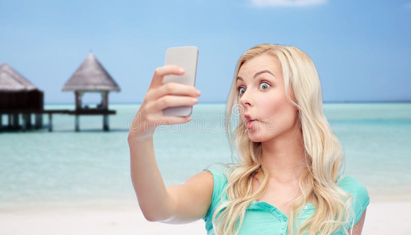 Giovane donna divertente che prende selfie con lo smartphone