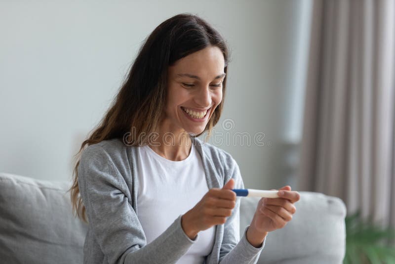 Giovane donna eccitata, soddisfatta dei risultati del test di gravidanza fotografia stock