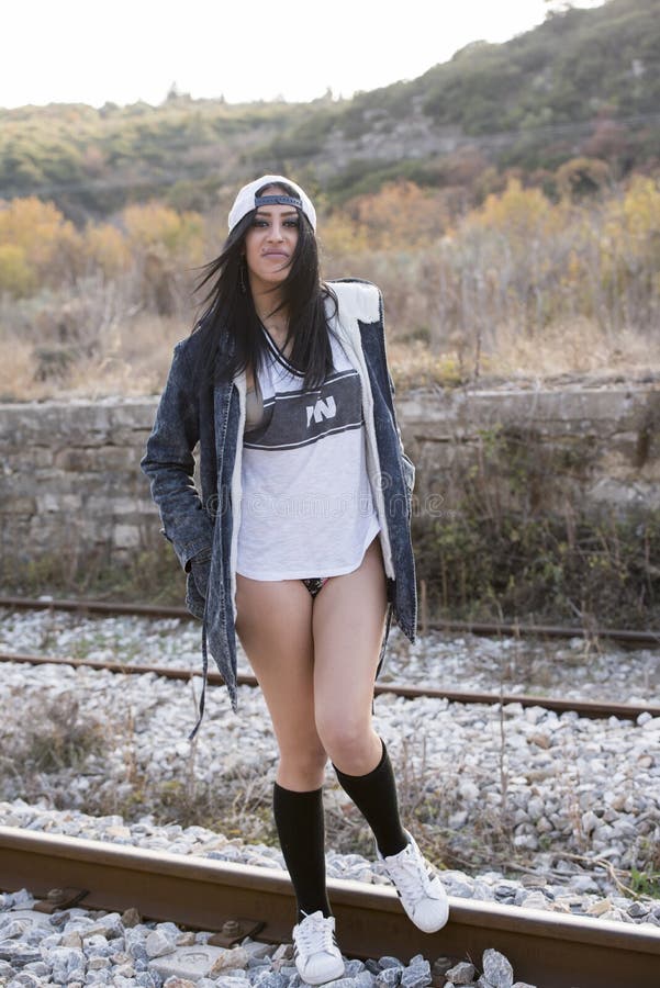Giovane donna esile sulle rotaie di un treno immagine stock Giovane donna esile sulle rotaie di un treno immagine stock