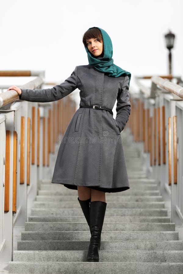 Giovane donna felice in cappotto classico sui punti fotografia stock Giovane donna felice in cappotto classico sui punti fotografia stock