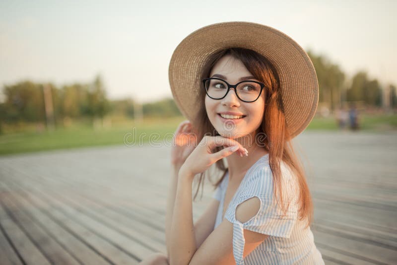 Giovane donna felice che si siede nel parco Fondo verde posteriore immagini stock Giovane donna felice che si siede nel parco Fondo verde posteriore immagini stock