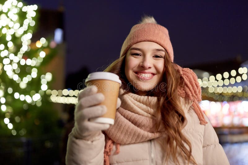 Giovane donna felice con caffè al mercato di natale immagine stock Giovane donna felice con caffè al mercato di natale immagine stock