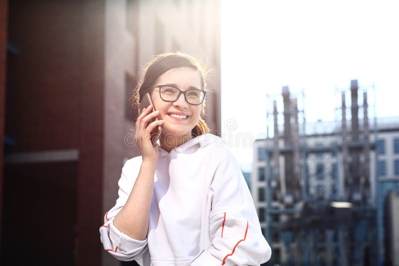 Giovane donna felice e sorridente che parla sul telefono fotografia stock libera da diritti Giovane donna felice e sorridente che parla sul telefono fotografia stock libera da diritti