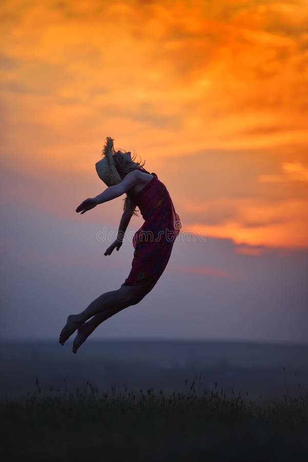 Giovane donna felice sul campo nel tramonto di estate fotografia stock libera da diritti Giovane donna felice sul campo nel tramonto di estate fotografia stock libera da diritti