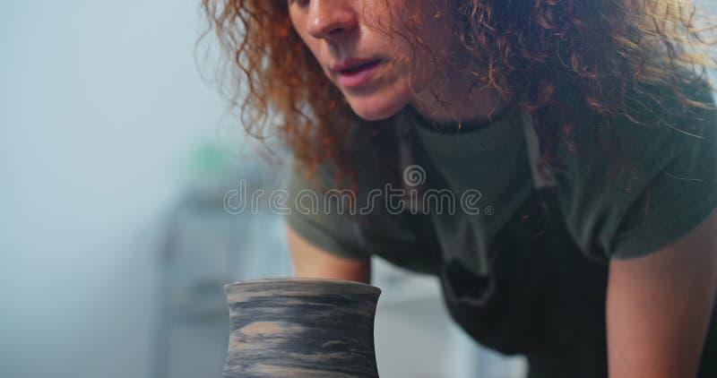 Giovane donna forma argilla sulla ruota di ceramica per creare un artista creativo fatto a mano nella ciotola di argilla