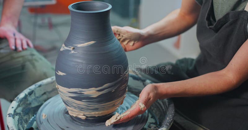 Giovane donna forma argilla sulla ruota di ceramica per creare un artista creativo fatto a mano nella ciotola di argilla
