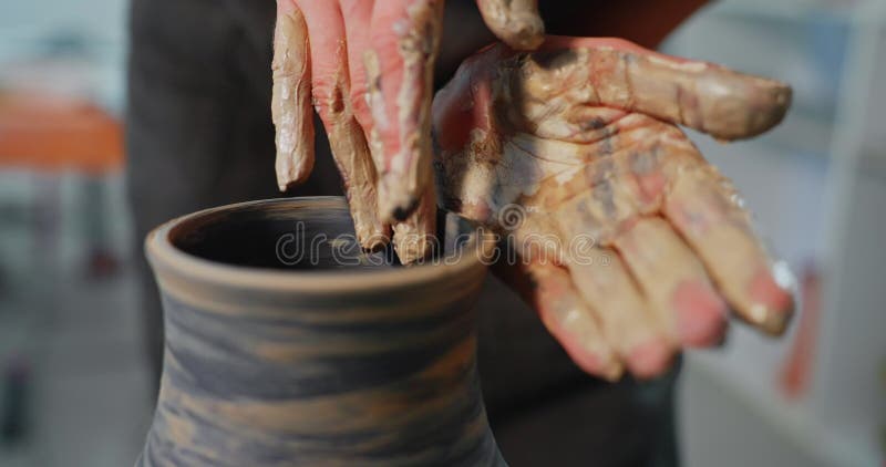 Giovane donna forma argilla sulla ruota di ceramica per creare un artista creativo fatto a mano nella ciotola di argilla