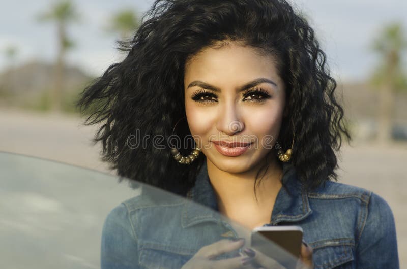 Giovane donna graziosa accanto alla sua automobile che fa telefonata fotografie stock Giovane donna graziosa accanto alla sua automobile che fa telefonata fotografie stock