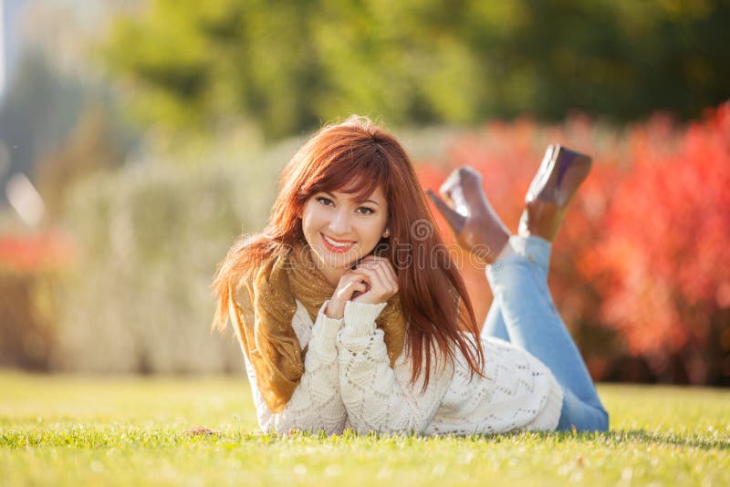 Giovane donna graziosa che si rilassa nel parco immagine stock Giovane donna graziosa che si rilassa nel parco immagine stock