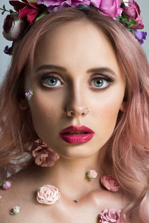 Giovane donna graziosa con la corona dei fiori rosa fotografie stock libere da diritti Giovane donna graziosa con la corona dei fiori rosa fotografie stock libere da diritti