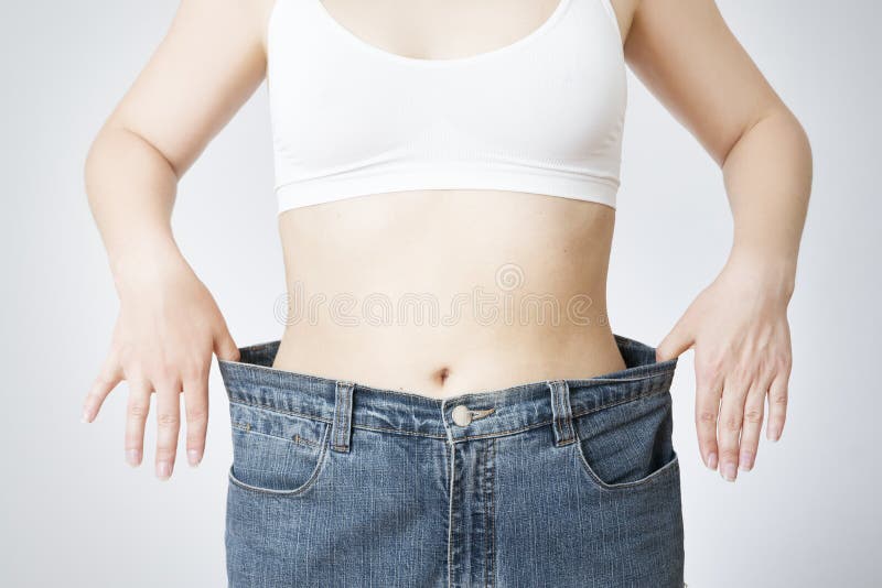 Giovane donna in jeans di grande, concetto di perdita di peso fotografia stock libera da diritti Giovane donna in jeans di grande, concetto di perdita di peso fotografia stock libera da diritti