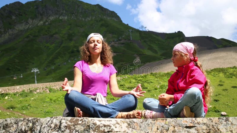 Giovane donna meditata e ragazza che la guarda in grande archivi video