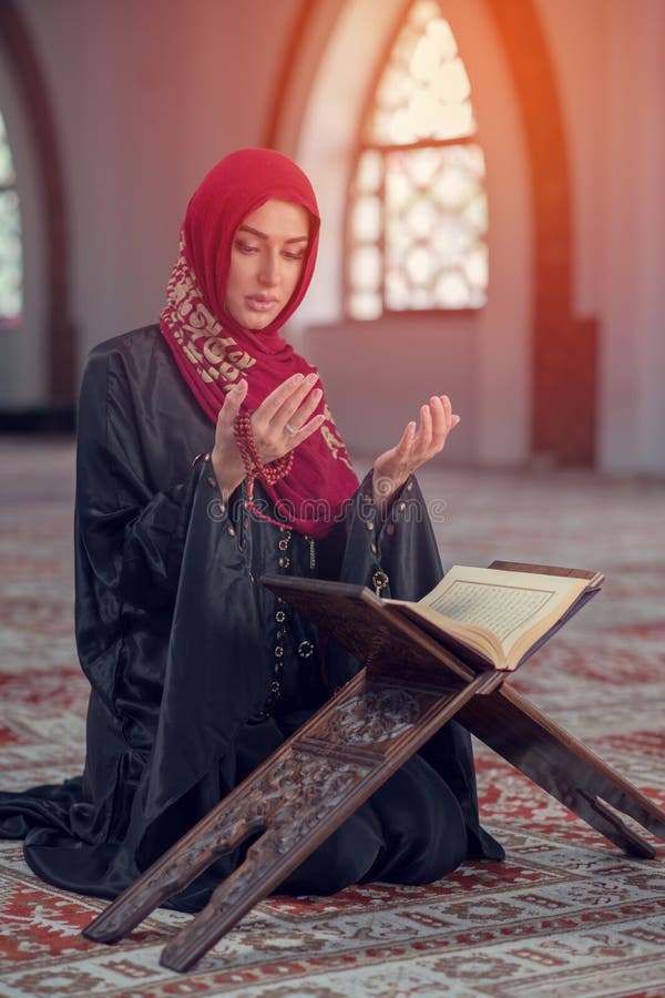 Giovane donna musulmana che prega con il rosario in moschea immagine stock Giovane donna musulmana che prega con il rosario in moschea immagine stock