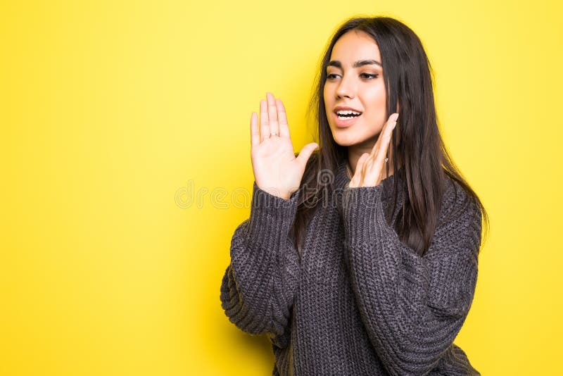 Giovane donna nel grido caldo del maglione isolata su fondo giallo fotografia stock libera da diritti Giovane donna nel grido caldo del maglione isolata su fondo giallo fotografia stock libera da diritti