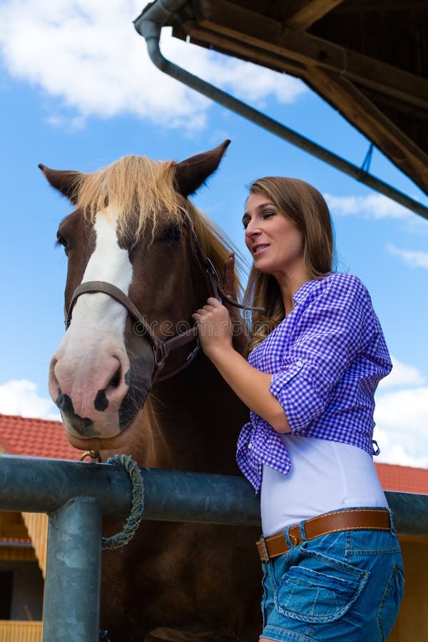Giovane Donna Nella Stalla Con Il Cavallo In Sole Fotografia Stock