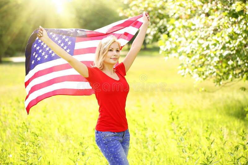 Giovane donna patriottica con la bandiera americana immagini stock Giovane donna patriottica con la bandiera americana immagini stock