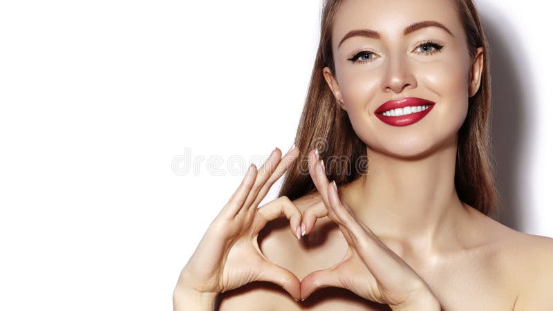 Giovane donna romantica che fa forma del cuore con le sue dita Amore e simbolo di giorno di biglietti di S. Valentino Ragazza di