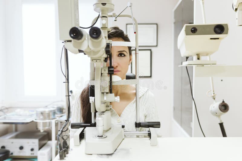giovane donna seduta alla clinica oftalmologa per farsi esaminare gli occhi da un professionista immagini stock libere da diritti giovane donna seduta alla clinica oftalmologa per farsi esaminare gli occhi da un professionista immagini stock libere da diritti