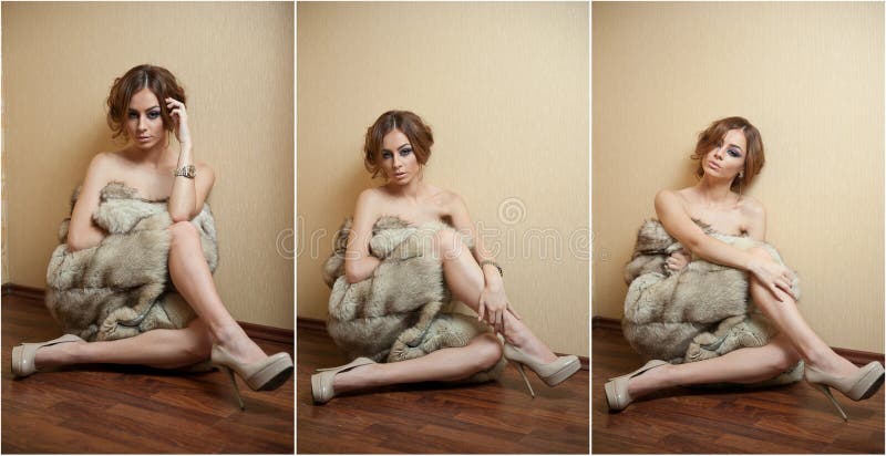 Giovane donna sexy attraente avvolta in una pelliccia che si siede sul pavimento nella camera di albergo Essere femminile della t immagine stock