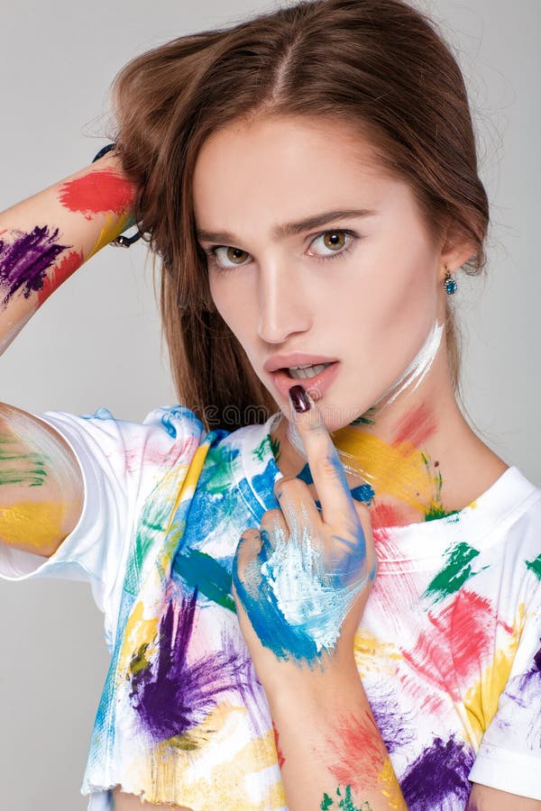Giovane donna spalmata in pittura multicolore fotografia stock Giovane donna spalmata in pittura multicolore fotografia stock