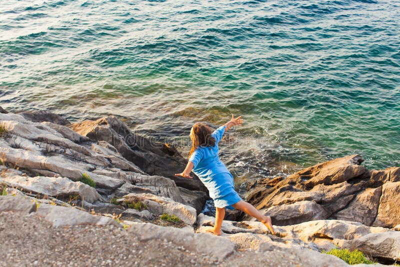 Giovane donna sulle rocce sopra il mare immagini stock libere da diritti Giovane donna sulle rocce sopra il mare immagini stock libere da diritti
