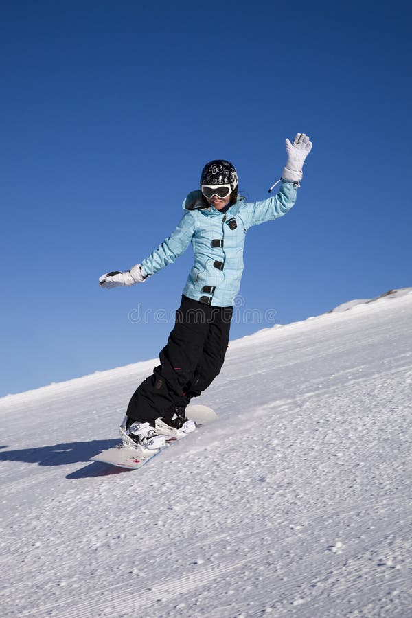 Giovane donna sullo snowboard sul pendio della montagna