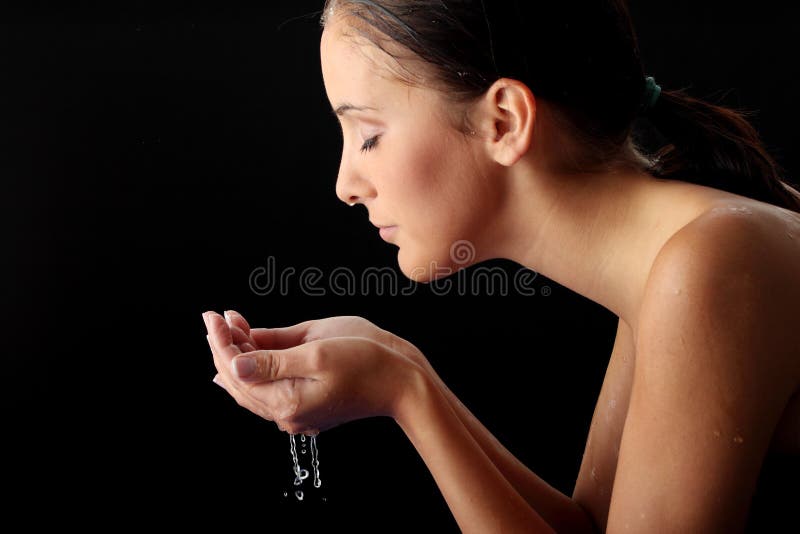 Young teen woman washing her face with clean water. Young teen woman washing her face with clean water