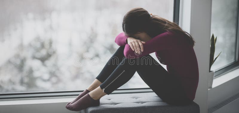 Giovane donna triste che piange nascondendo la faccia sola e triste in casa isolata. problema di salute mentale ansia sociale pani