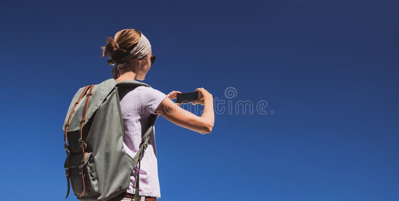 Giovane donna turista che usa uno smartphone per scattare foto sullo sfondo del cielo azzurro concetto di viaggio, turismo, vacan immagine stock Giovane donna turista che usa uno smartphone per scattare foto sullo sfondo del cielo azzurro concetto di viaggio, turismo, vacan immagine stock